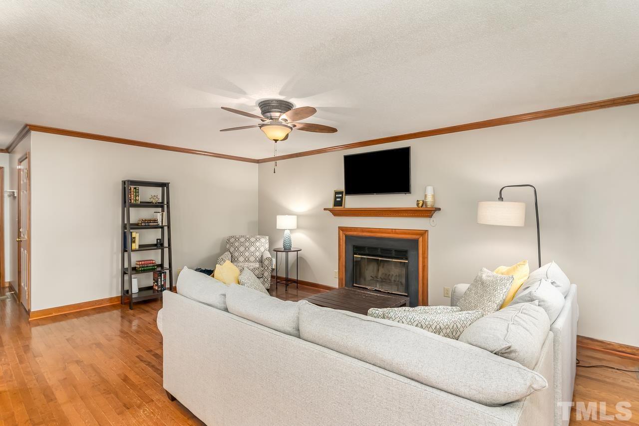 5504 Spring Pines Way Raleigh, NC 27616 - Photo 5 of 25 a living room with furniture a fireplace and a flat screen tv