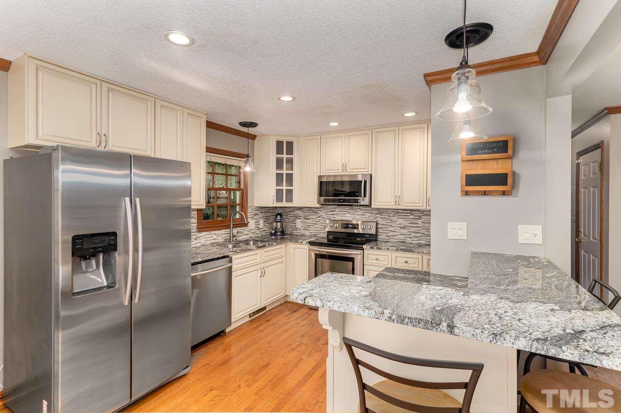 5504 Spring Pines Way Raleigh, NC 27616 - Photo 10 of 25 a kitchen with stainless steel appliances granite countertop a sink refrigerator stove and microwave