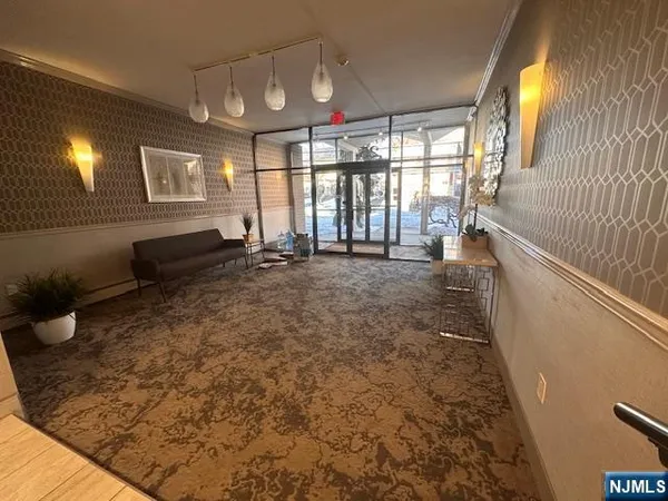 a view of a hallway to the room with wooden floor