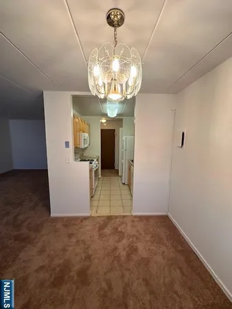 a view of a dining room with a chandelier fan and kitchen view