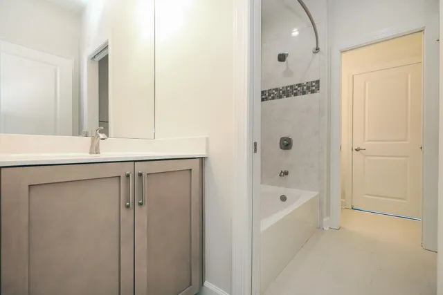 a bathroom with a tub shower and a sink