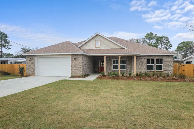 a front view of a house with a garden and yard