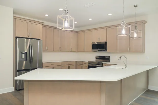 a kitchen with kitchen island a sink stainless steel appliances and refrigerator