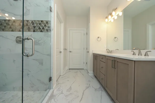 a bathroom with a double vanity sink mirror and shower