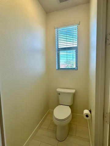 a bathroom with a toilet and a window