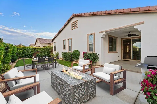 a view of a patio with couches table and chairs and potted plants