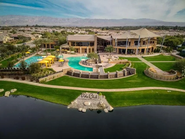 a view of a swimming pool with lawn chairs and a big yard