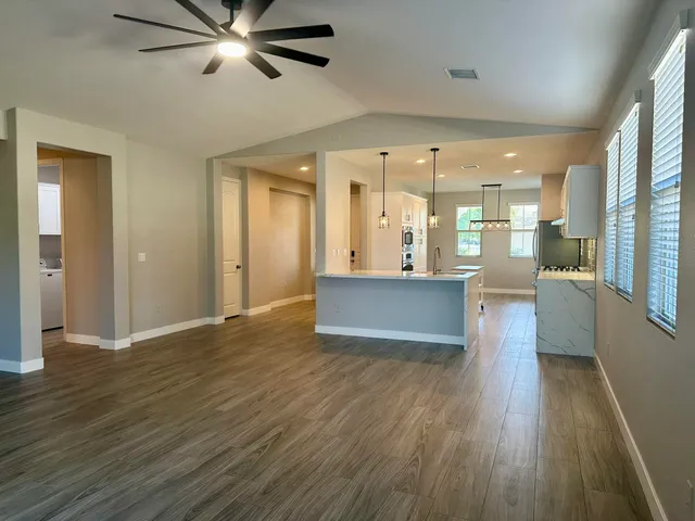 a view of a big room with wooden floor and windows