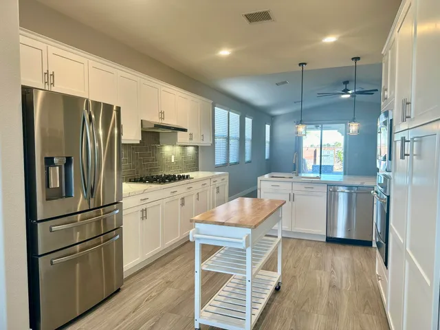 a kitchen with a refrigerator a sink and cabinets