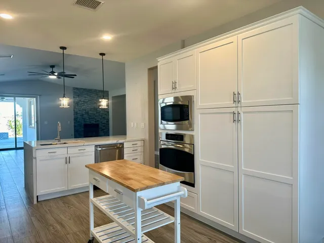 a kitchen with a refrigerator a stove cabinets and wooden floor