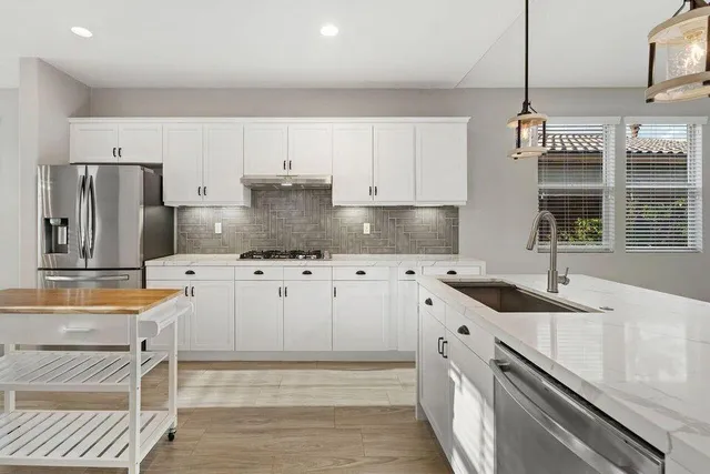 a kitchen with granite countertop a sink stove and refrigerator