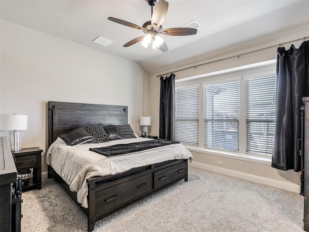 1216 Tree Shadow Lane Anna, TX 75409 - Photo 16 of 37 a bed sitting in a bedroom next to a large window