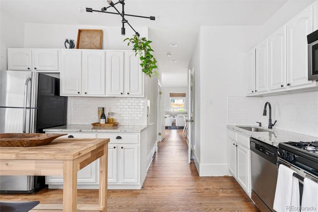 a kitchen with stainless steel appliances a stove refrigerator sink and cabinets