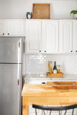 a kitchen with stainless steel appliances a refrigerator and white cabinets