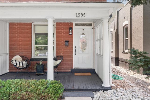 a view of front door of house with outdoor seating