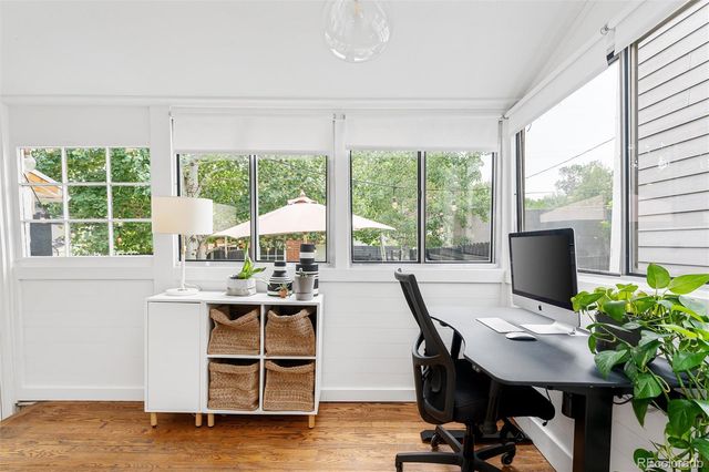 a view of a workspace with furniture and a window