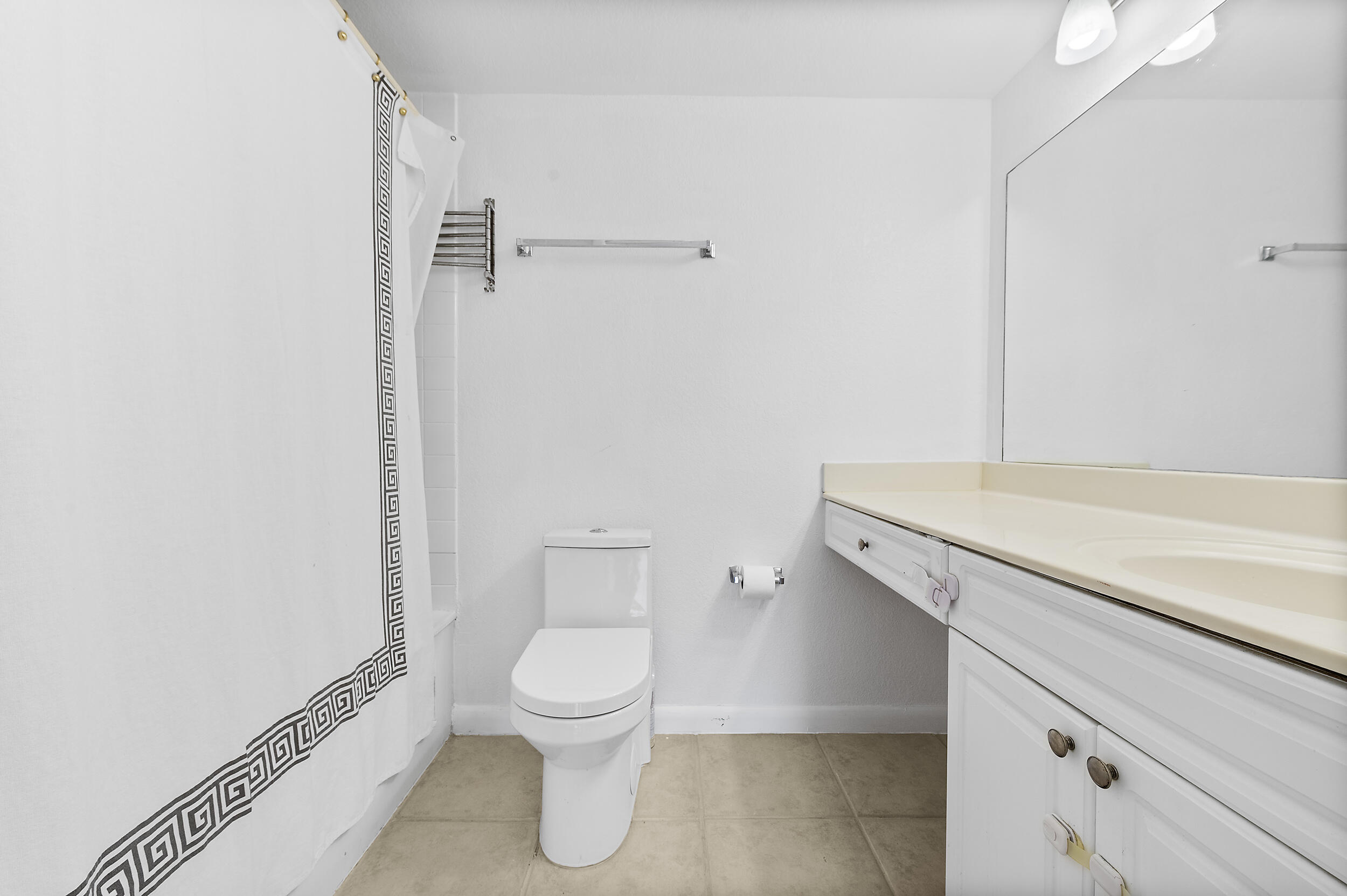 8141 Severn Drive, Unit B Boca Raton, FL 33433 - Photo 23 of 34 a white toilet sitting next to a bathroom sink