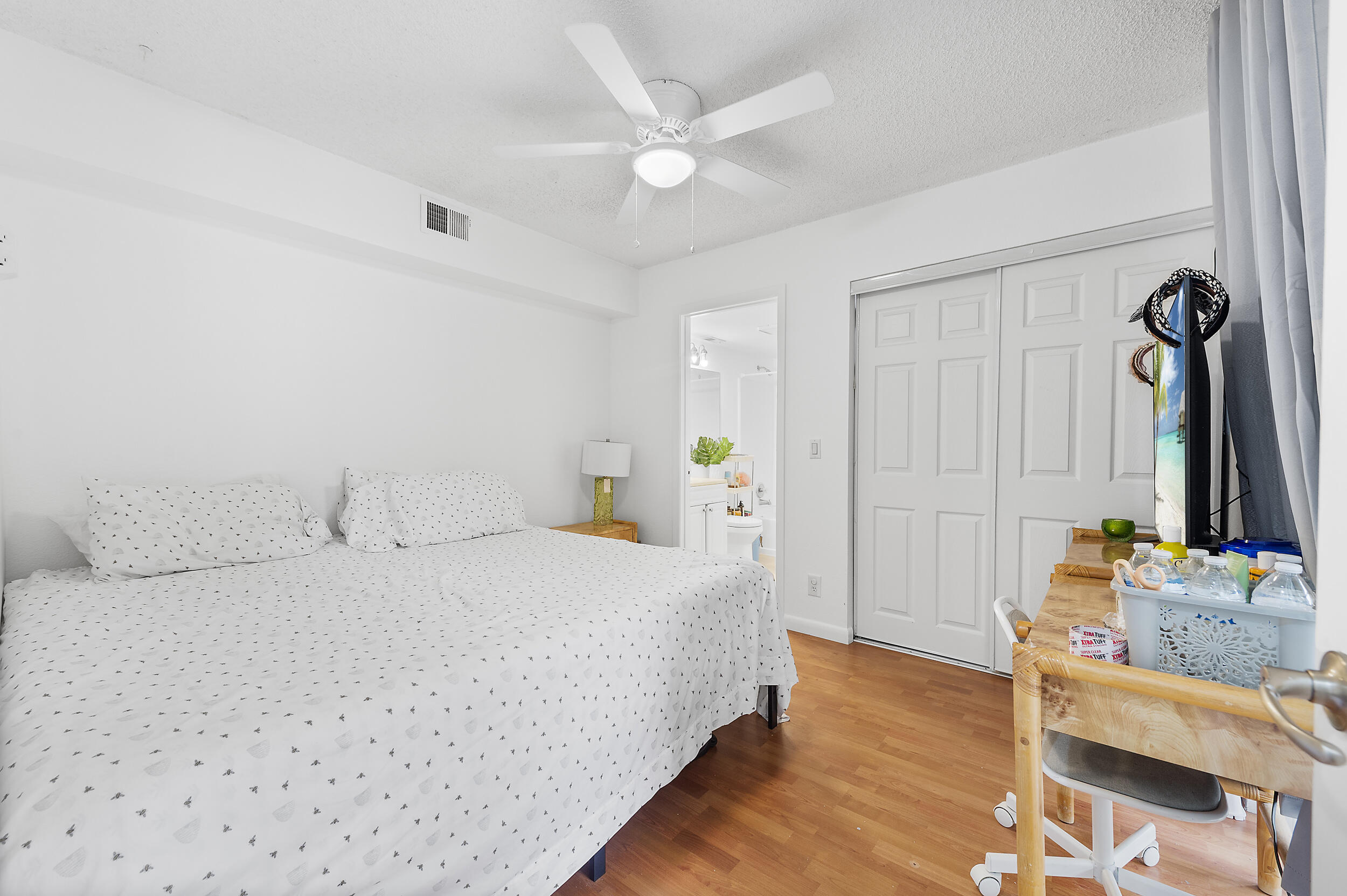 8141 Severn Drive, Unit B Boca Raton, FL 33433 - Photo 24 of 34 a bedroom with a bed and a dresser with wooden floor