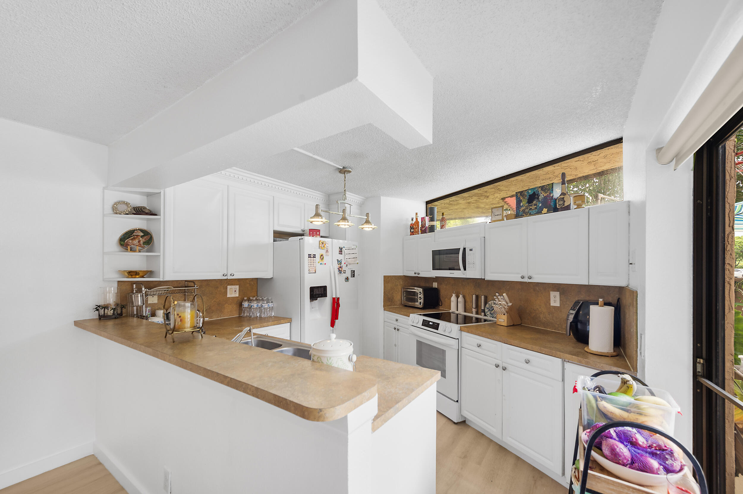 8141 Severn Drive, Unit B Boca Raton, FL 33433 - Photo 6 of 34 a kitchen with sink cabinets and stove top oven