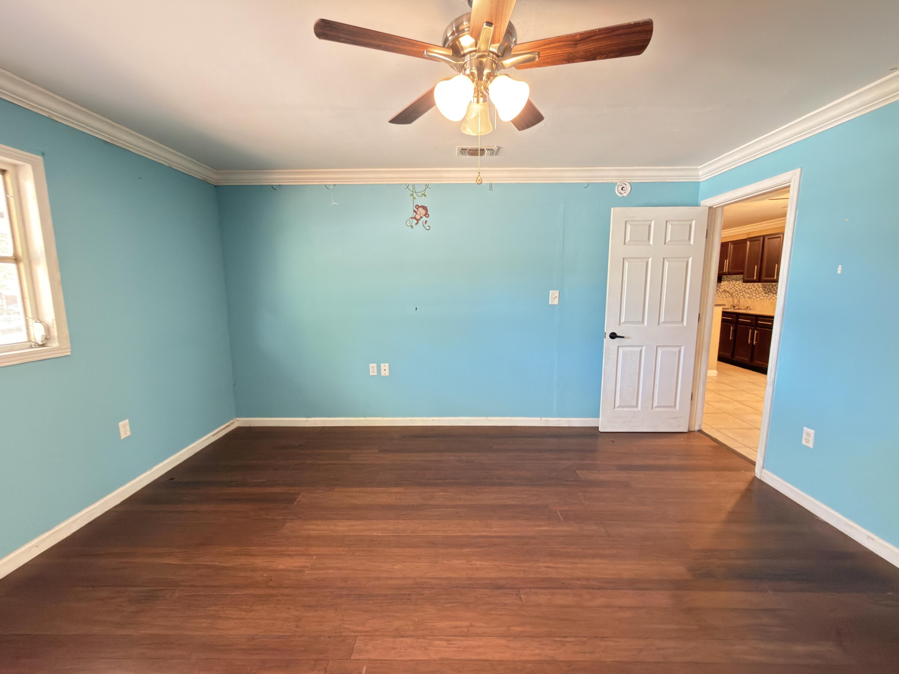 515 Robinson Avenue East Crestview, FL 32539 - Photo 13 of 22 a view of an empty room with window and wooden floor