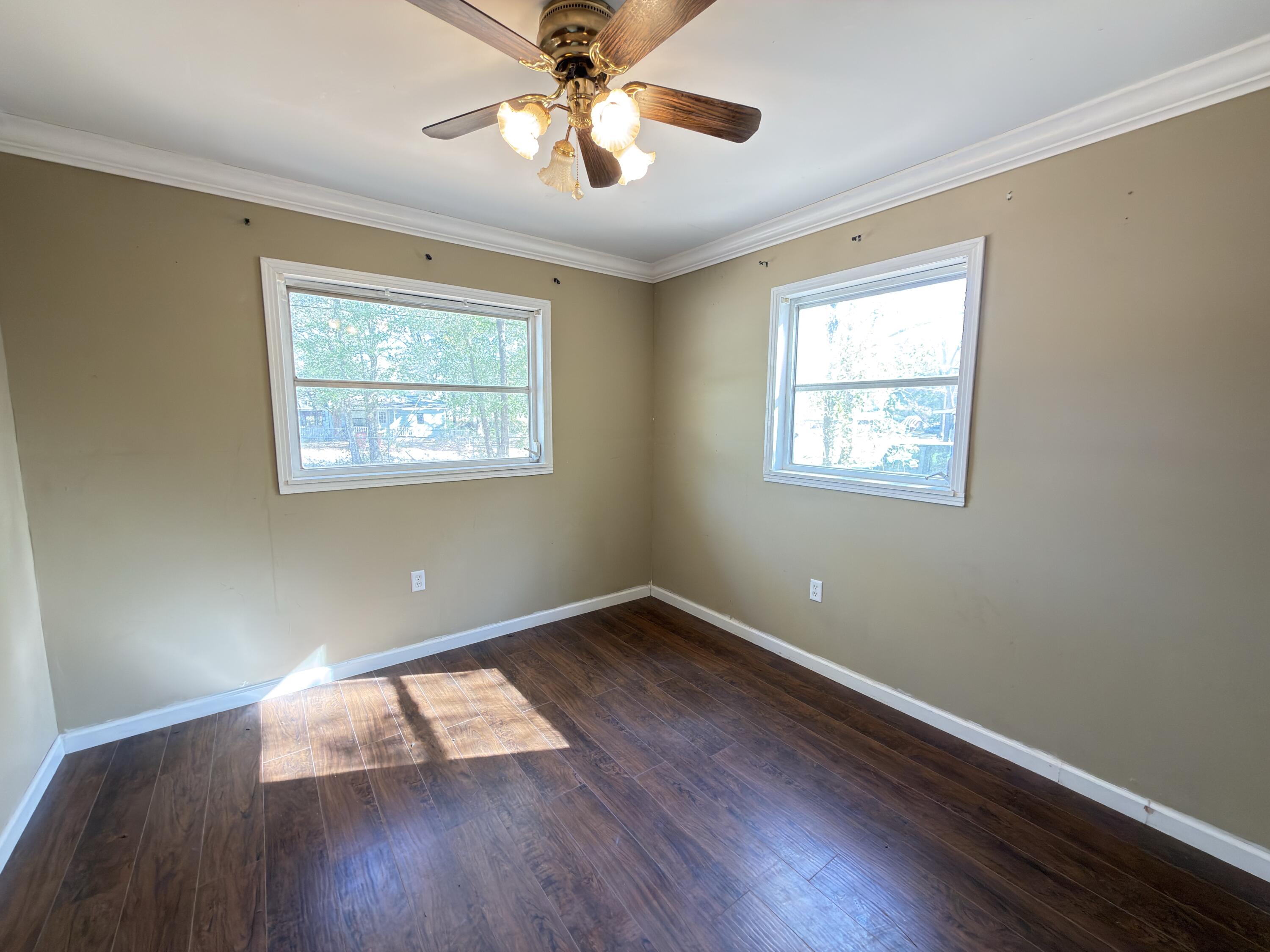 515 Robinson Avenue East Crestview, FL 32539 - Photo 21 of 22 a view of an empty room with wooden floor and a window