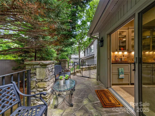 a view of a patio with table and chairs and potted plants with wooden floor and fence