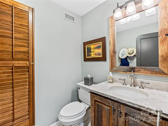 a bathroom with a granite countertop sink toilet and a mirror