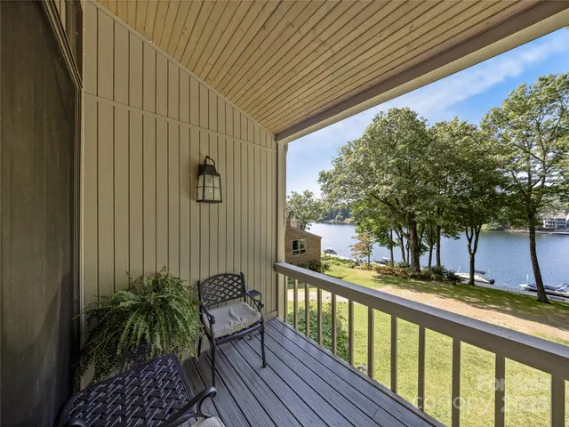 a view of a balcony with chairs and wooden fence