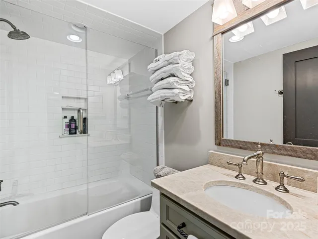 a bathroom with a sink vanity granite tub and shower