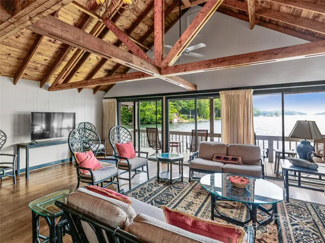 a living room with furniture a flat screen tv and a large window