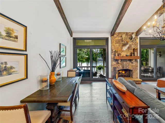 a living room with furniture a fireplace and large windows