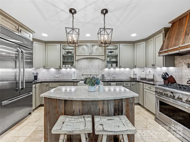 a kitchen with stainless steel appliances granite countertop a sink refrigerator and cabinets