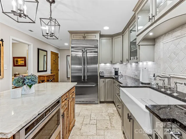 a kitchen with stainless steel appliances granite countertop a sink a stove and cabinets