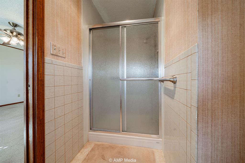 1102 Elmdale Road North Abilene, TX 79601 - Photo 12 of 28 a bathroom with a glass shower door