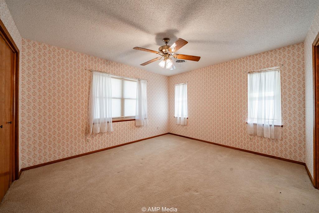 1102 Elmdale Road North Abilene, TX 79601 - Photo 8 of 28 an empty room with chandelier fan and windows