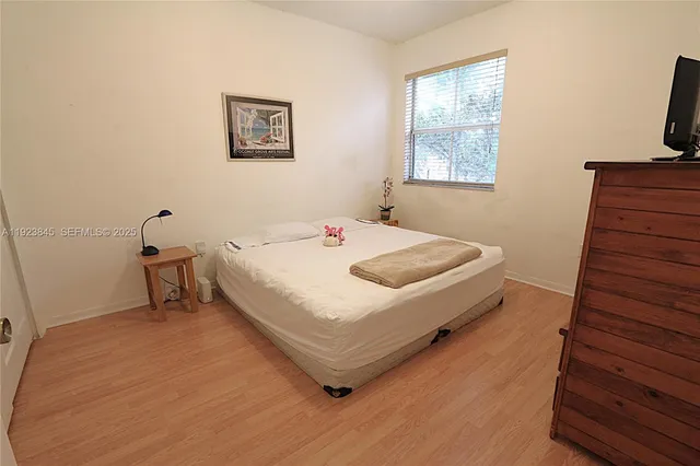 a bedroom with a bed and wooden floor