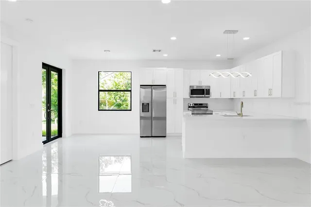 a view of kitchen with stainless steel appliances refrigerator oven and cabinets