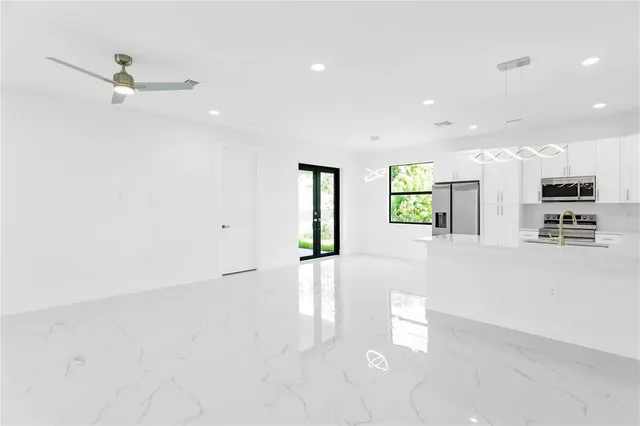 an empty room with fan and windows