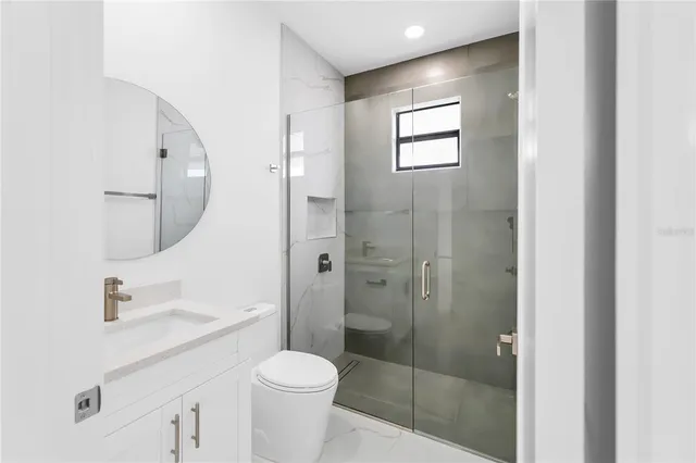 a bathroom with a toilet a sink and glass door