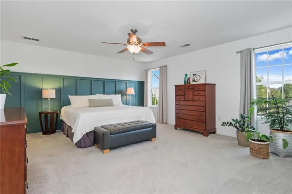 a spacious bedroom with a bed and a potted plant