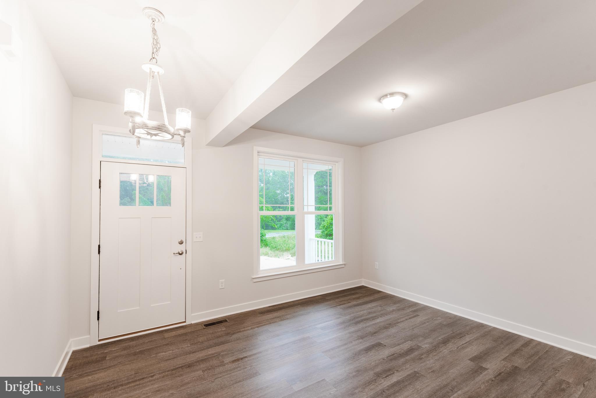 10625 Plank Road Spotsylvania, VA 22553 - Photo 2 of 26 an empty room with wooden floor windows and chandelier