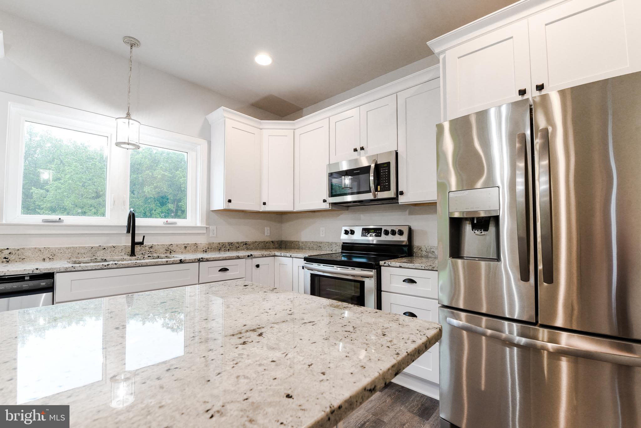10625 Plank Road Spotsylvania, VA 22553 - Photo 24 of 26 a kitchen with stainless steel appliances granite countertop a refrigerator a stove a sink dishwasher a microwave oven with white cabinets and wooden floor