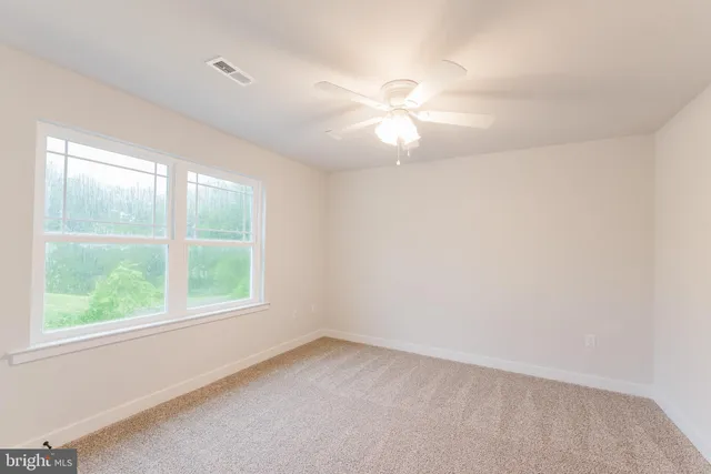 an empty room with a window and a fan