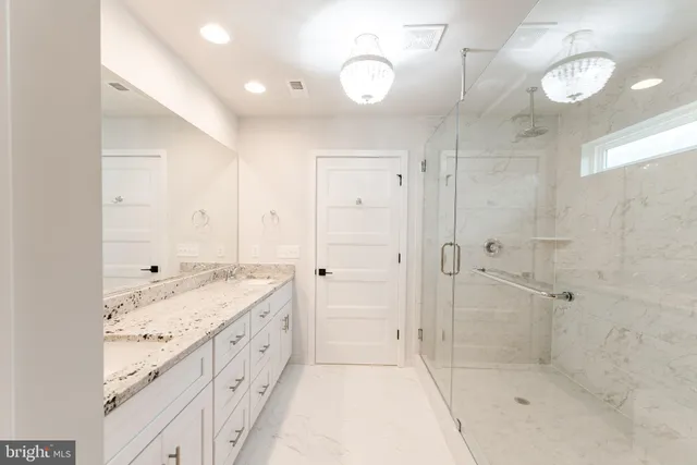 a bathroom with a granite countertop sink a shower and a mirror