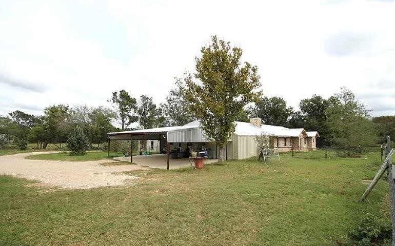 a view of a house with a yard table and chairs