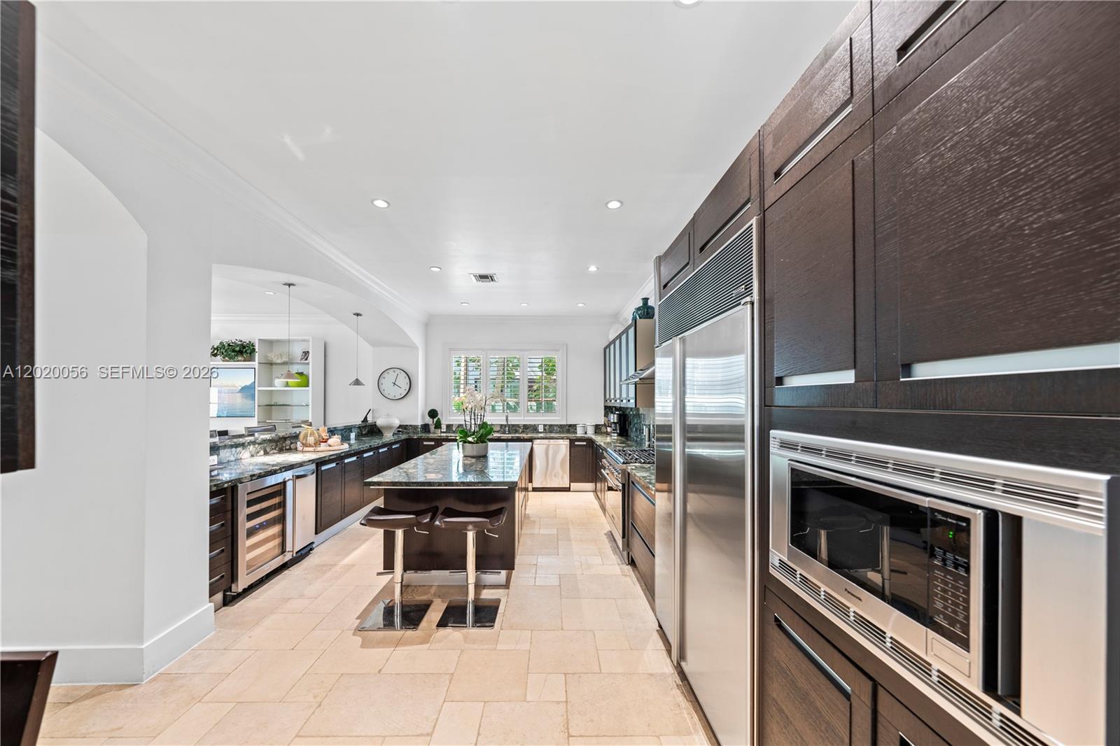 4196 Douglas Road Miami, FL 33133 - Photo 27 of 96 a kitchen with stainless steel appliances kitchen island granite countertop a stove a sink dishwasher and a refrigerator