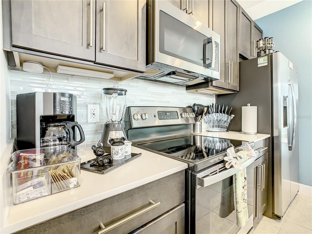 181 Villa Domani Circle Davenport, FL 33896 - Photo 12 of 37 a kitchen with stainless steel appliances granite countertop a sink and cabinets