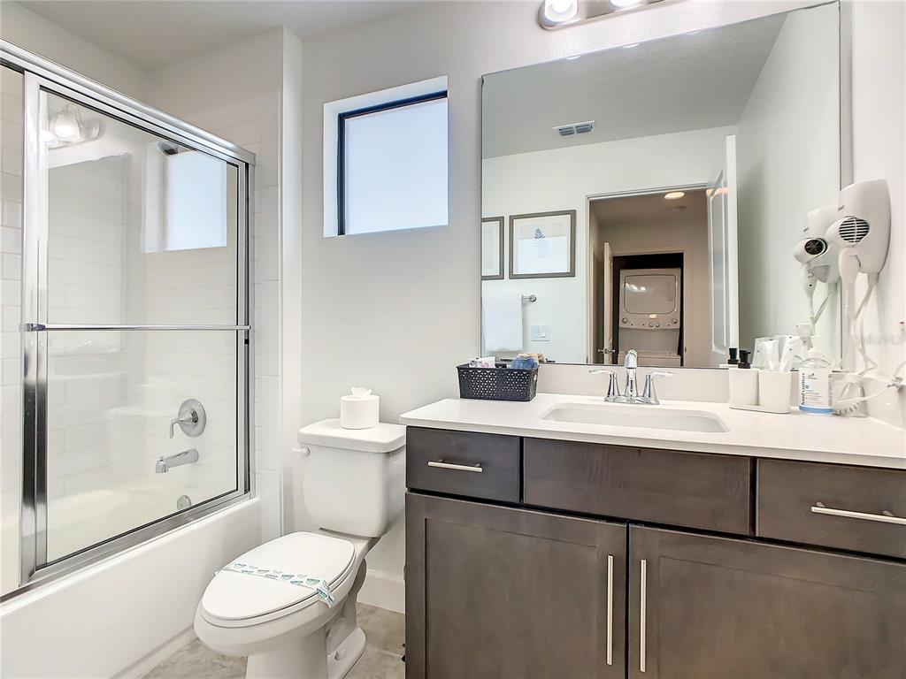 181 Villa Domani Circle Davenport, FL 33896 - Photo 23 of 37 a bathroom with a toilet a sink and mirror