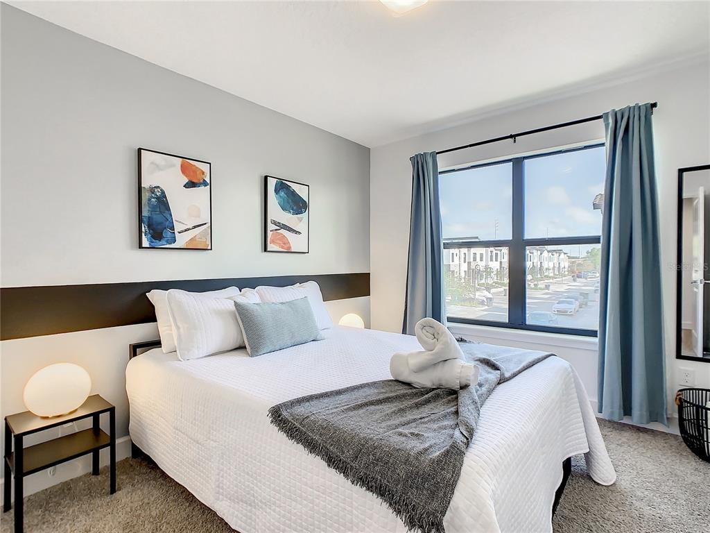 181 Villa Domani Circle Davenport, FL 33896 - Photo 25 of 37 a bedroom with a bed and a large window