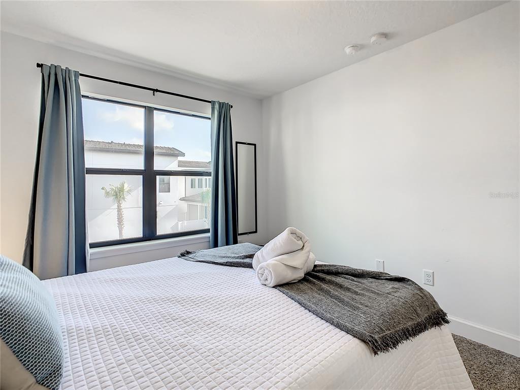 181 Villa Domani Circle Davenport, FL 33896 - Photo 26 of 37 a bedroom with a bed and a large window